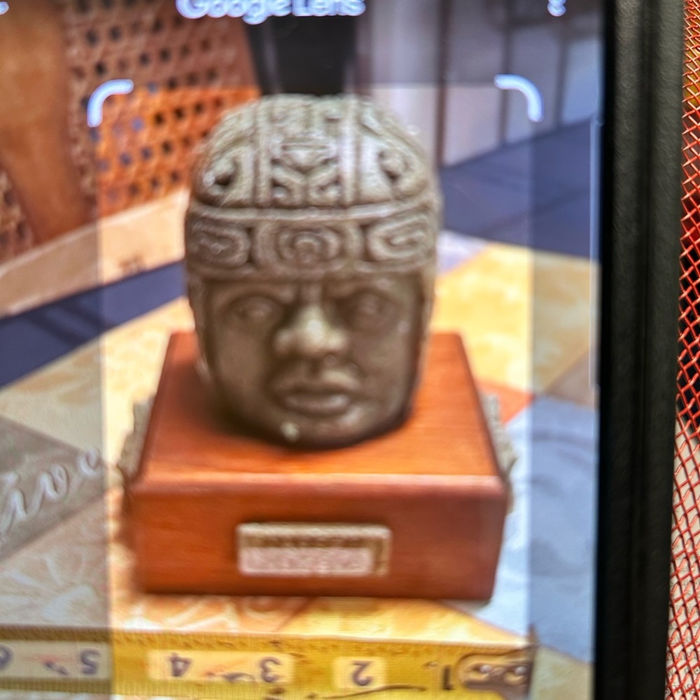 Intricate Stone Head Sculpture on Wooden Base